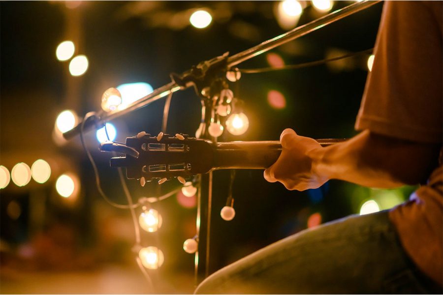 Close up of a man with a guitar at an outdoor music concert