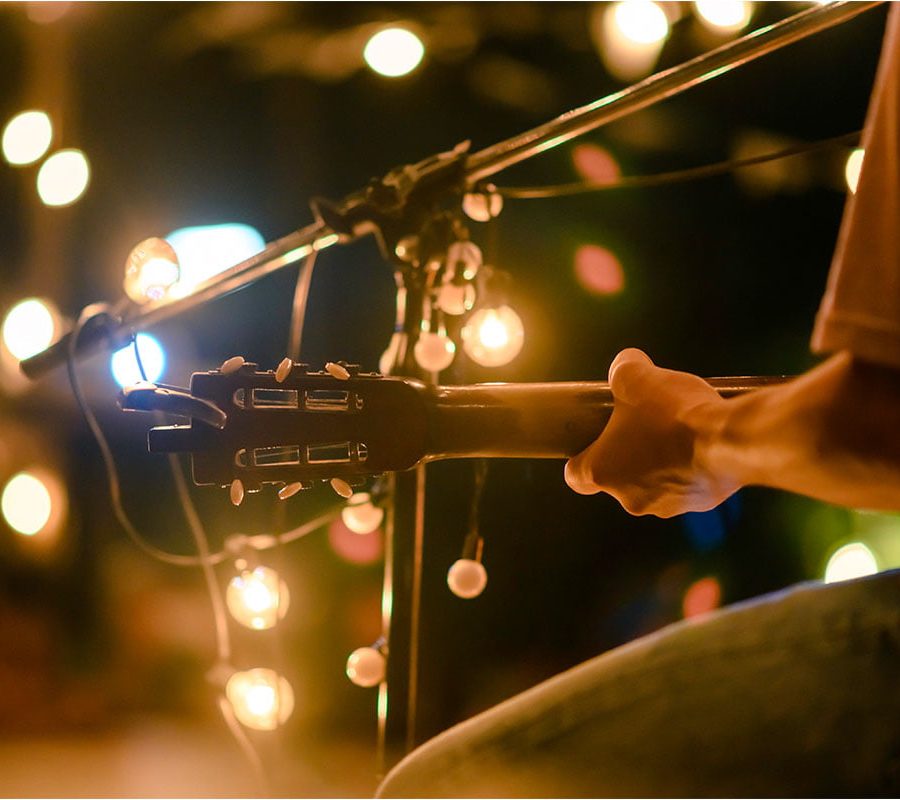Close up of a man with a guitar at an outdoor music concert