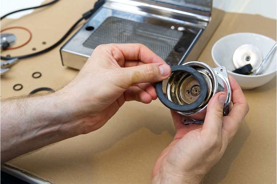 Close up of hands repairing machinery