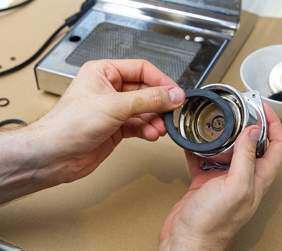 Close up of hands repairing machinery