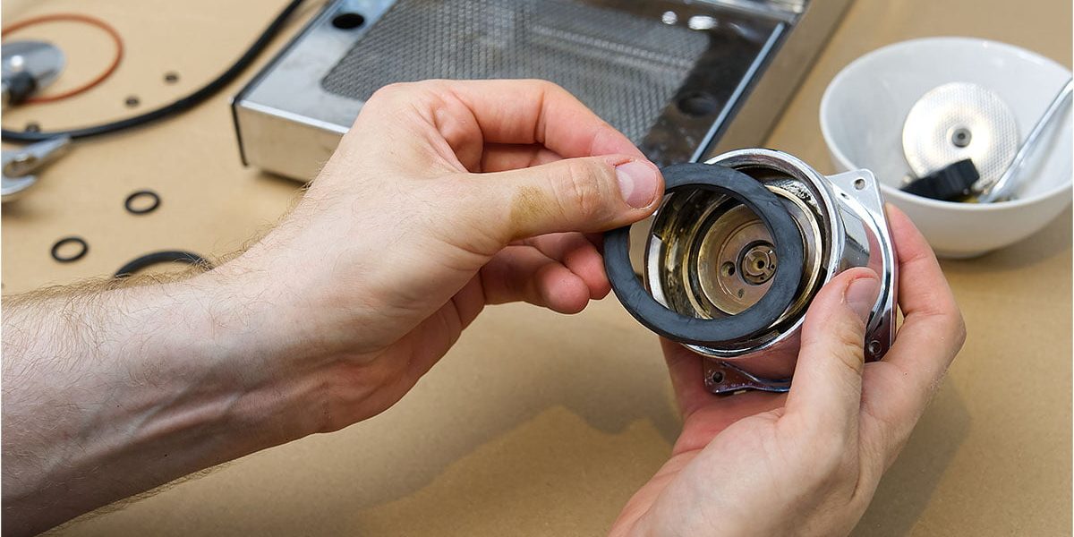 Close up of hands repairing machinery