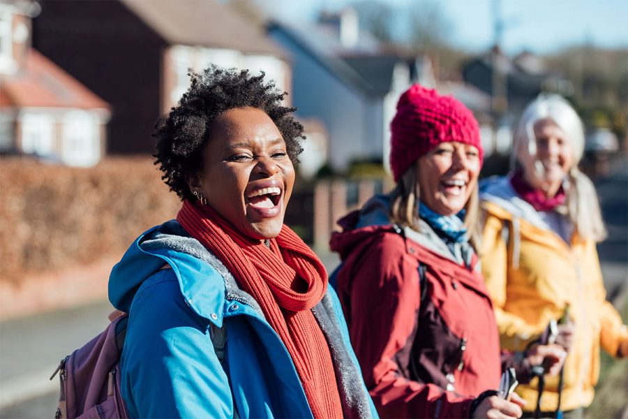 Three smiling women in outdoor gear