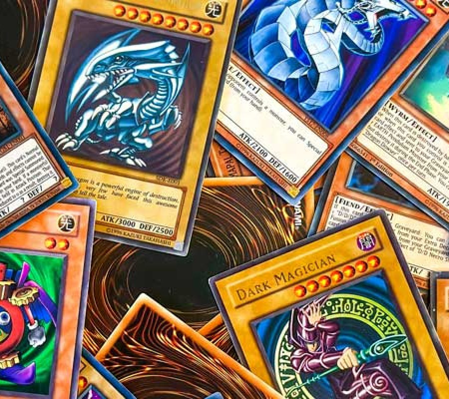A pile of Yu-Gi-Oh cards, some on their front, others on their back