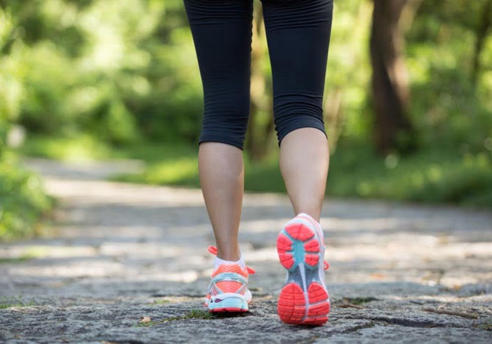 young fitness woman hiker legs at forest trail