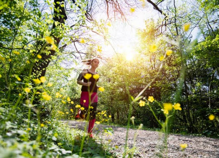 Young sporty woman jogging through the forest.