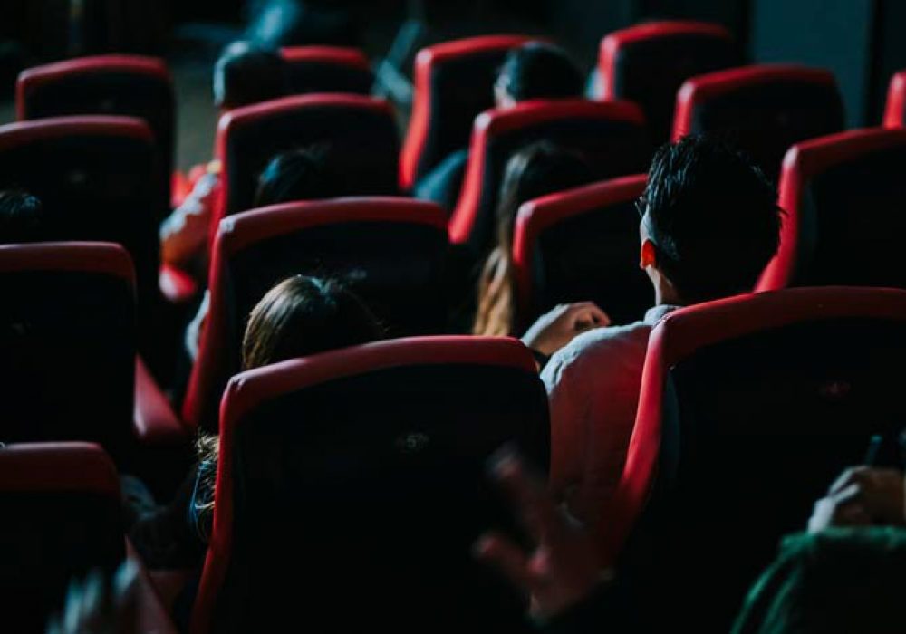 rear view asian chinese group of audience watching 3D movie in cinema enjoying the show with 3D glasses screaming excitement