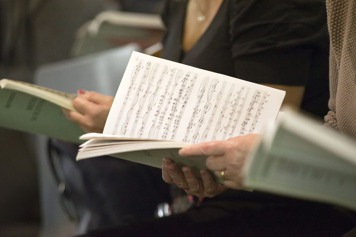 Choir singers female hands holding musical scores