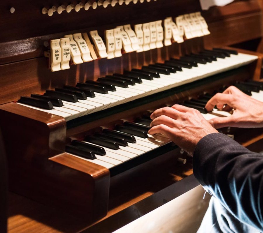 Germany, Europe: Detail of a man playing a organ.