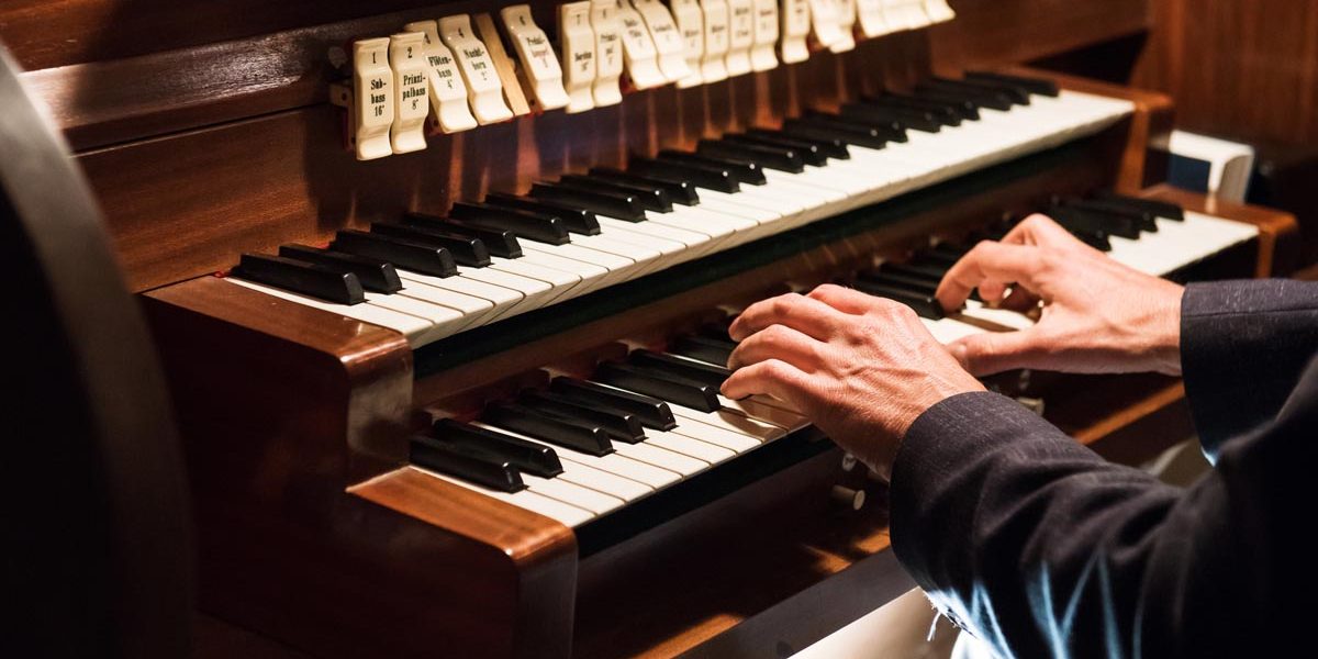 Germany, Europe: Detail of a man playing a organ.