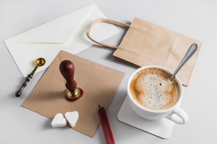 Vintage stationery with coffee cup on grey paper background.