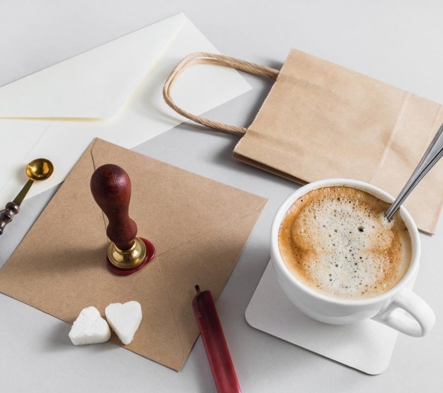 Vintage stationery with coffee cup on grey paper background.