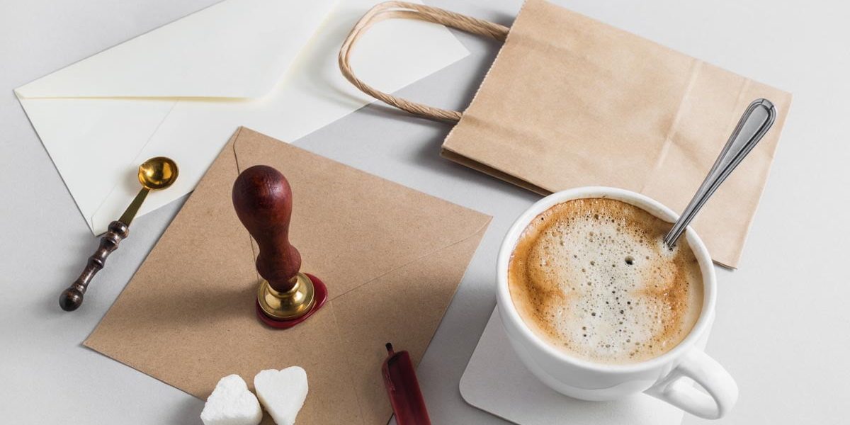 Vintage stationery with coffee cup on grey paper background.