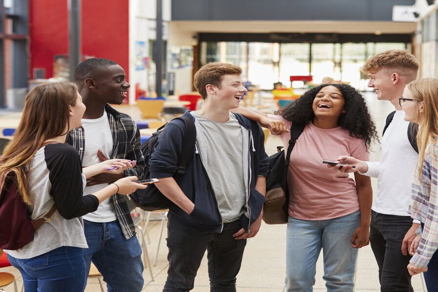 Student Group Socializing In Communal Area Of Busy College