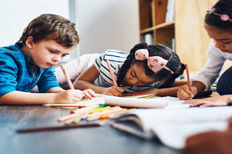 Cropped shot of kids coloring in while lying on the floor