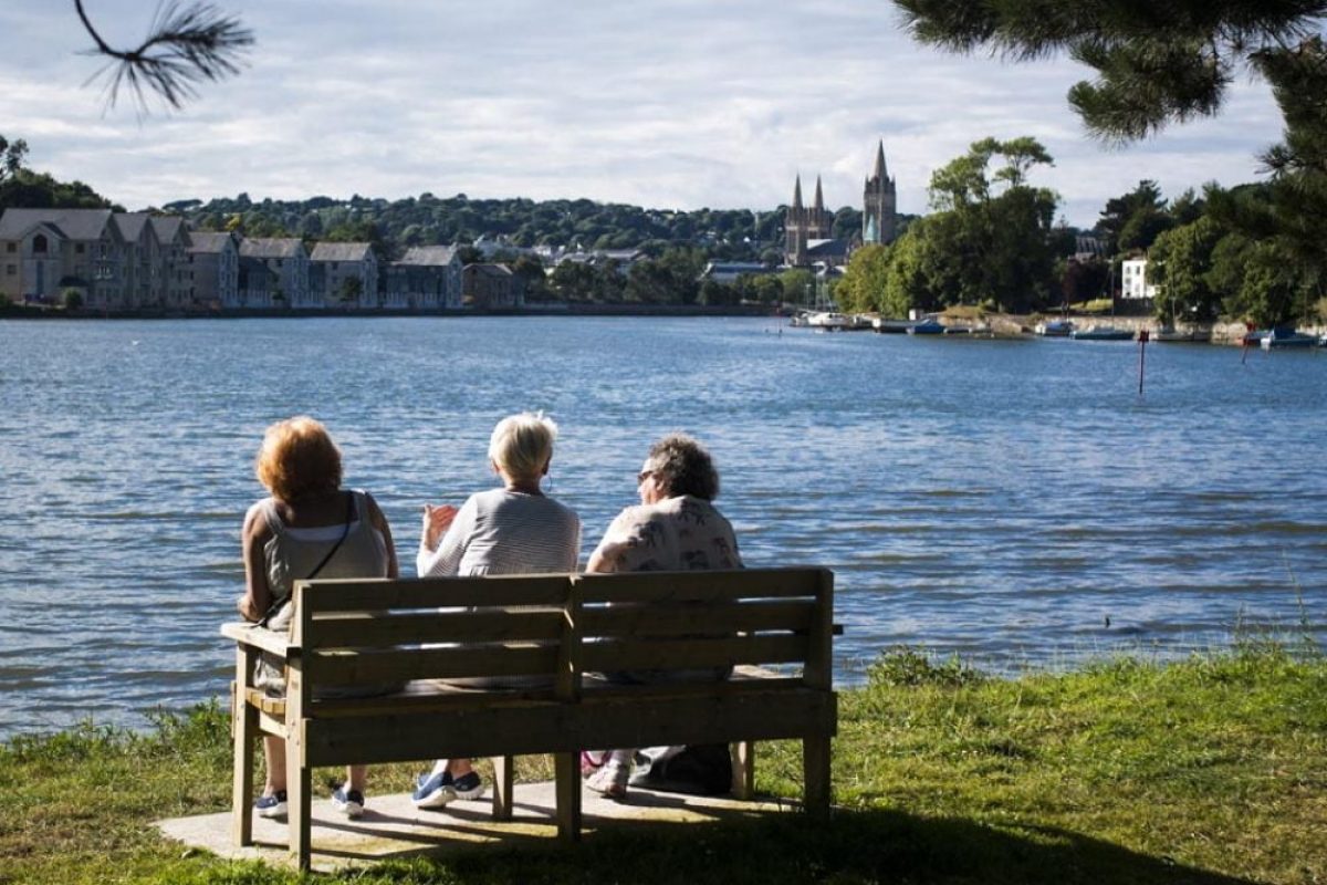 Three ladies sat on a bench overlooking the river at Truro